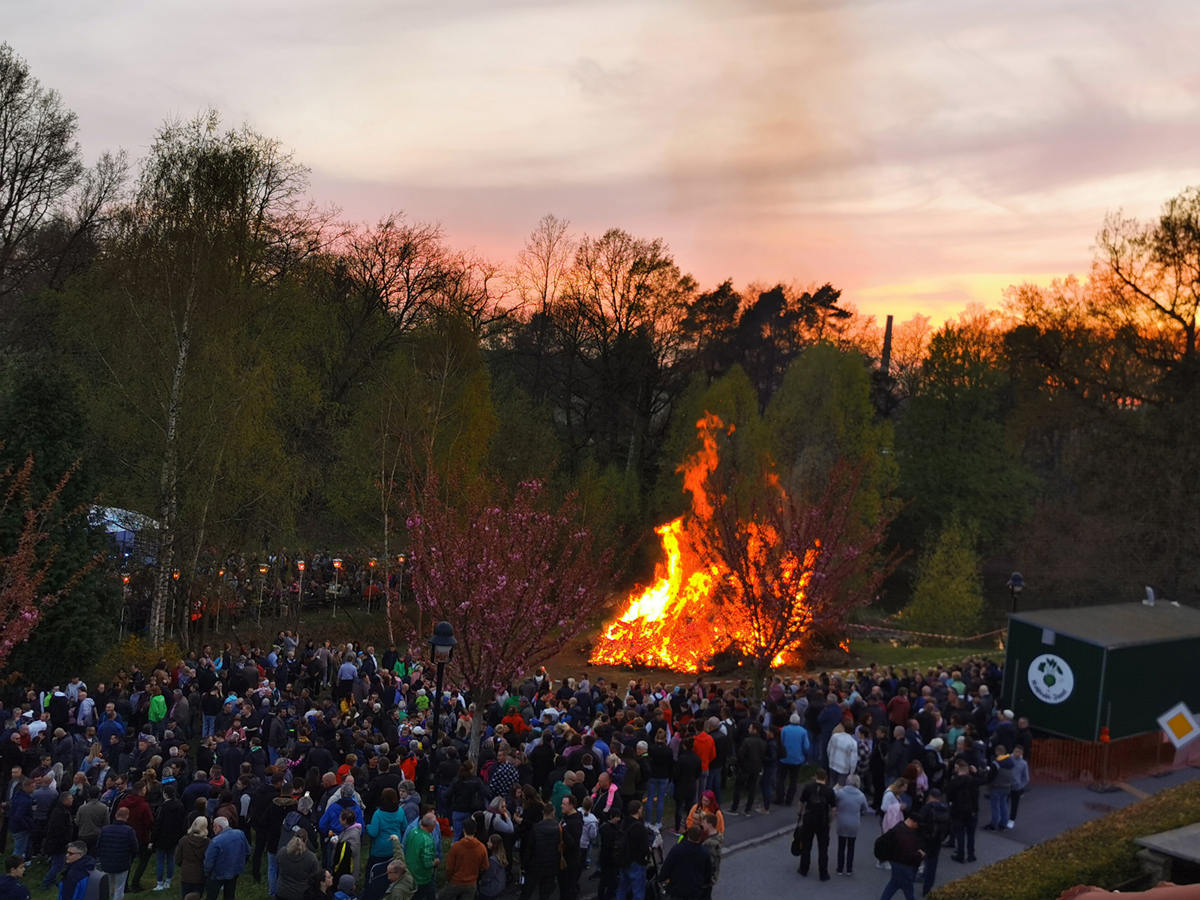 Große Menschenmenge beim Kohlrabi-Inselfest vor einem großen Lagerfeuer bei Sonnenuntergang.