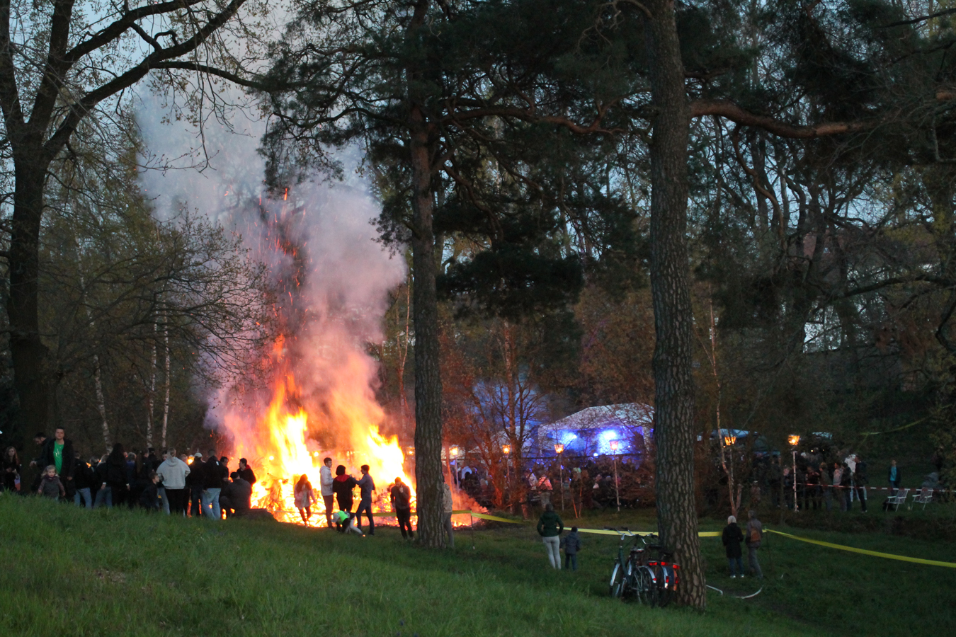 Großes Lagerfeuer im Wald bei Dämmerung.